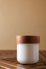 Jar of luxury cream on wooden table, space for text