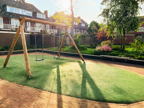 Outdoor wooden swings at backyard on sunny day