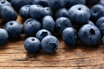 Many tasty fresh blueberries on wooden table, closeup
