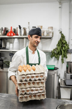chef carrying eggs in a kitchen