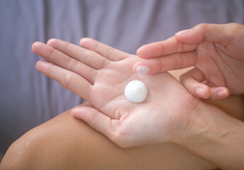 Asia woman applying moisturizing cream/lotion on hands, beauty concept.