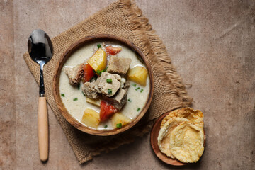 Soto Betawi. Traditional beef and offal soup from Betawi, Jakarta. The soup has been preplated in a bowl; ready to be served.