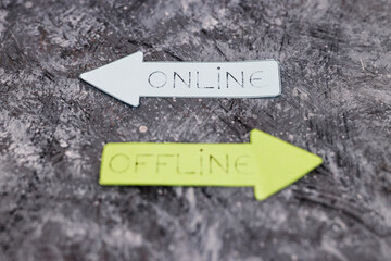 Online and Offline alternatives on arrows pointing at opposite directions with the Online option in focus, social media or business model concept