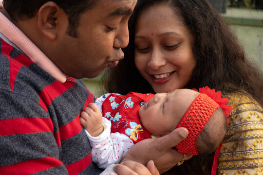 A Cute Kid In The Lap Of Her Father At Outdoors In Winter Evening Time