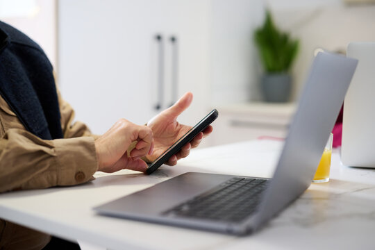 Up-to-date elderly man with mobile and laptop.