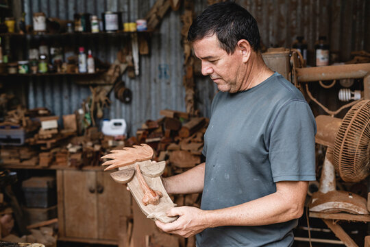 man looking at his woodwork
