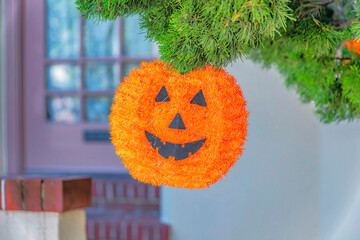 Hanging tinsel plaque pumpkin holloween ornament outside a residence in San Francisco, California