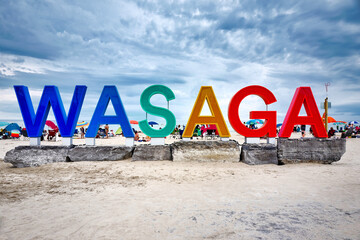 Colourful giant Wasaga beach text sign background on big rocks at Ontario famous popular summer...