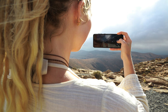 Young woman making picture of view
