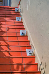 Outdoor terracotta tiles staircase with buckets on the side near the beige wall- San Francisco, CA