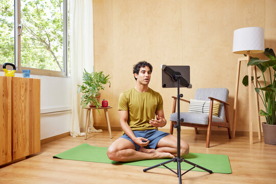 Hispanic man shooting video for yoga vlog