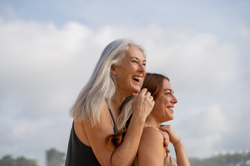 Naklejka premium laughing mother and adult daughter at the beach portrait