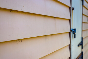 old weatherboard wall and bolted door in selective focus