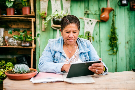 Latina woman checking a tablet in her store