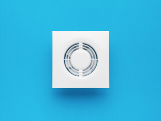 Stylish white wall fan on a blue background. Minimal ventilation concept.