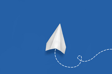 Paper plane on blue background, top view