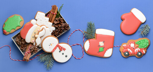 Tasty Christmas cookies on blue background, top view