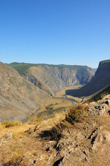 A deep canyon sandwiched in the mountains and a winding river flowing along the bottom.