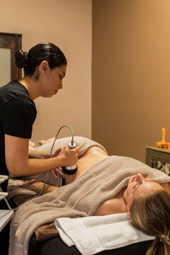 therapist giving cavitation laser massage to a woman 