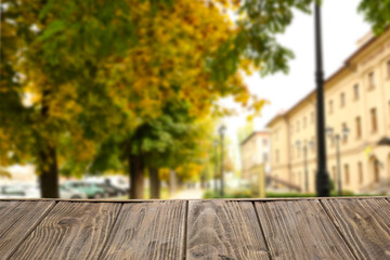 Naklejka na ściany i meble Empty wooden table on city street on autumn day