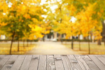 Naklejka na ściany i meble Empty wooden table in autumn city park