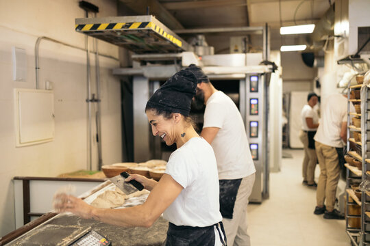 Bread Makers Working With Dough In Bakehouse