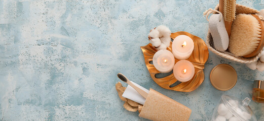 Set of bath supplies and candles on light blue background with space for text
