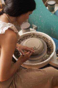 Woman Making A Bowl On The Pottery Wheel