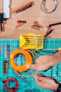 Detail of male hands cutting wires with scalpel.