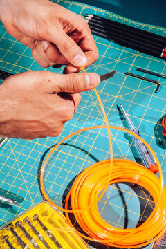 Detail of male hands cutting wires with scalpel.