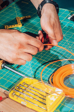 Detail of male hands cutting wires with scalpel.
