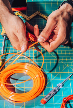 Detail of male hands cutting wires with scalpel.