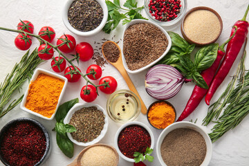 Different spices, vegetables and herbs on light background