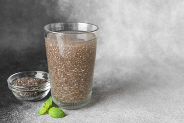 Glass of water with chia seeds on black and white background