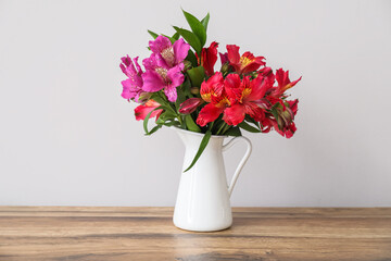 Vase with beautiful alstroemeria flowers on wooden table