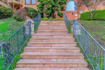 Marble stairs with wrought iron railings on a slope against the residences in San Francisco, CA
