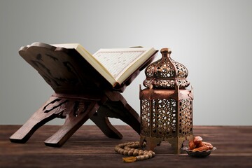 The Holy Al Quran with written Arabic calligraphy and rosary beads or tasbih,