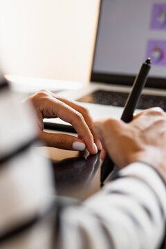 Close-up of female hands drawing on a graphics tablet