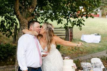 Bride and Groom Kissing after First Bite of Cake