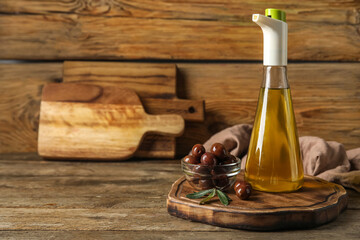 Board with bottle of oil and olives on wooden background