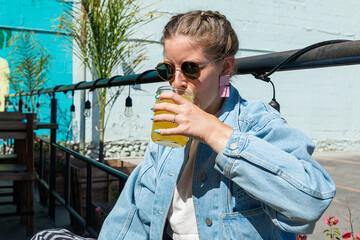 A woman drinking an orange water at a restaurant