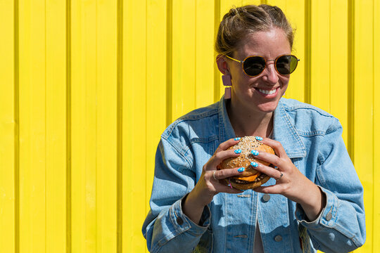 Smiling woman eating a vegan burger