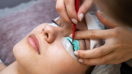 Young woman undergoing eyelash tinting and lamination procedure.