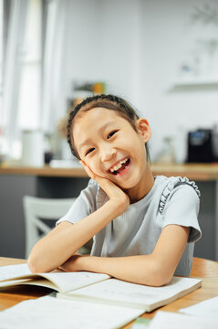 Schoolgirl studying and smiling at cameras
