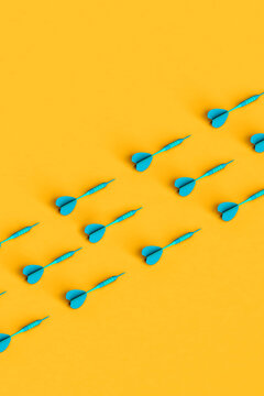 rows of blue darts on yellow background