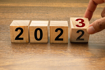 Countdown to 2023. Hand holding of wooden cubes with the letters 2023 on a wooden table