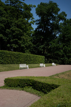 Three white metal benches in the green park
