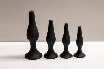 Four black silicone anal plugs on the white background. Sex toys set