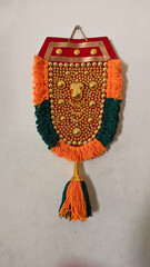 a handcrafted, gold, decorative ornament used on elephants forehead called nettipattam for festivals hanged on a wall