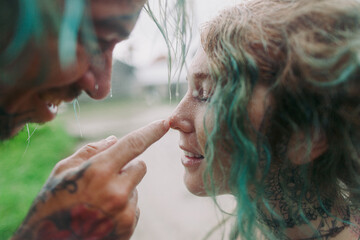 Young couple embracing under the tropic rain 